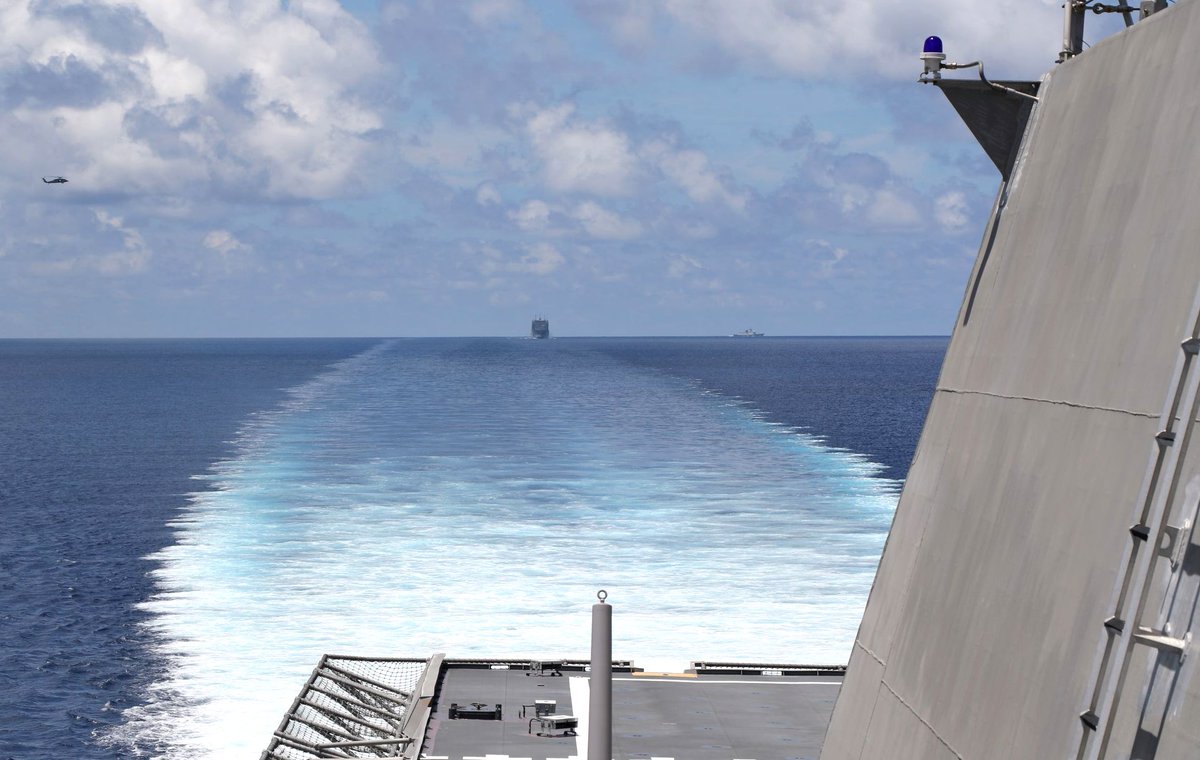 US Navy littoral combat ship MONTGOMERY LCS8, on a western Pacific deployment, cruises the South China Sea 7 May with supply ship CESAR CHAVEZ T-AKE14 astern and a Chinese Type 054A frigate shadow on the horizon 